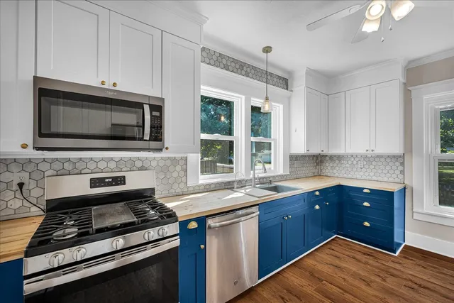 a kitchen with stainless steel appliances a stove sink and cabinets