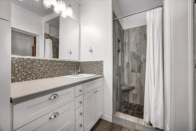 a bathroom with a shower sink and mirror