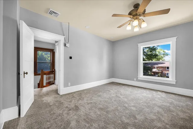 an empty room with fan and windows