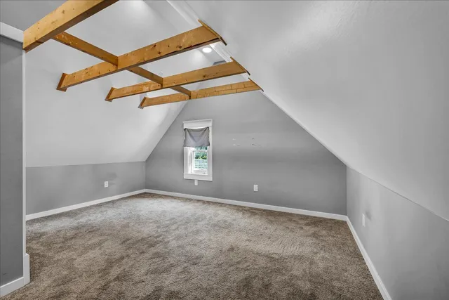 an empty room with a ceiling fan and carpet