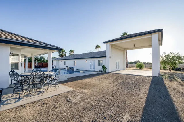 a view of a house with a yard and palm trees