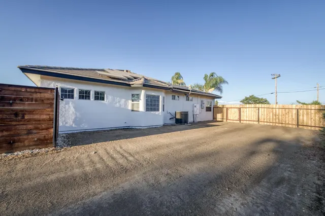 a front view of a house with swimming pool having outdoor seating