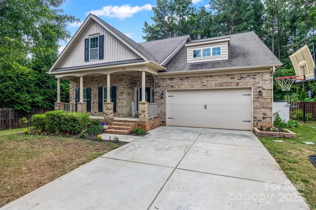 a view of a white house with large windows and a small yard