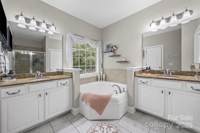 a bathroom with a tub sink and mirror