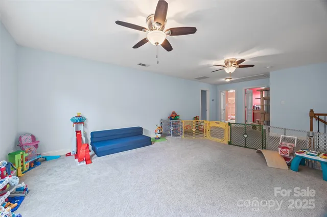 a living room with furniture and a ceiling fan