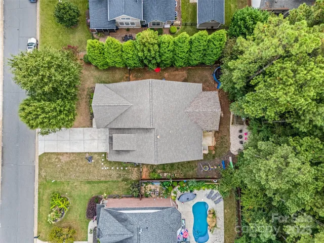 an aerial view of a house with a yard and large trees