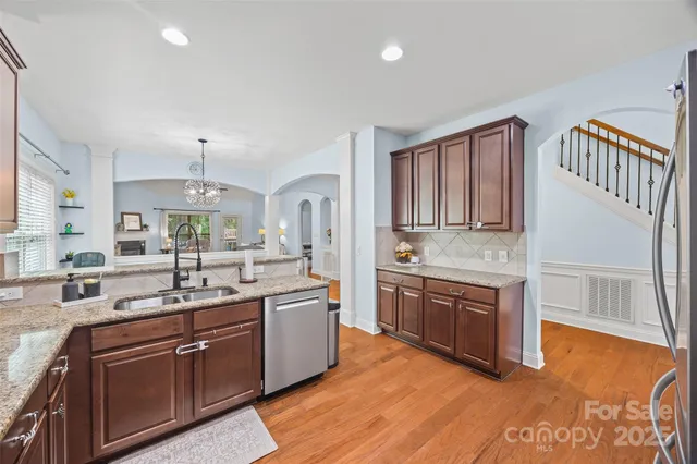 a kitchen with stainless steel appliances granite countertop a sink stove and cabinets
