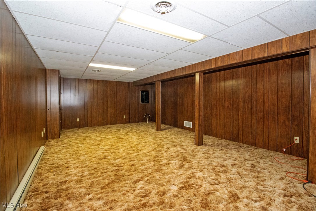 1675 South Funk Road Wooster, OH 44691 - Photo 26 of 34 Basement with light colored carpet, a baseboard radiator, and wooden walls