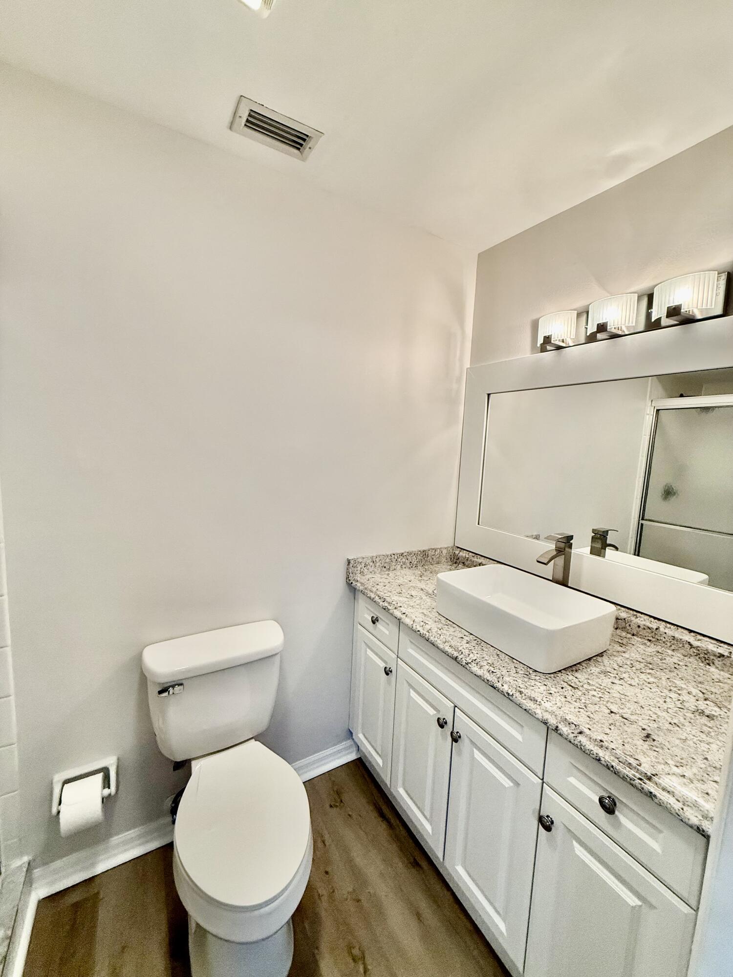 1900 South Kanner Highway, Unit 10207 Stuart, FL 34994 - Photo 11 of 19 a bathroom with a granite countertop toilet sink and mirror