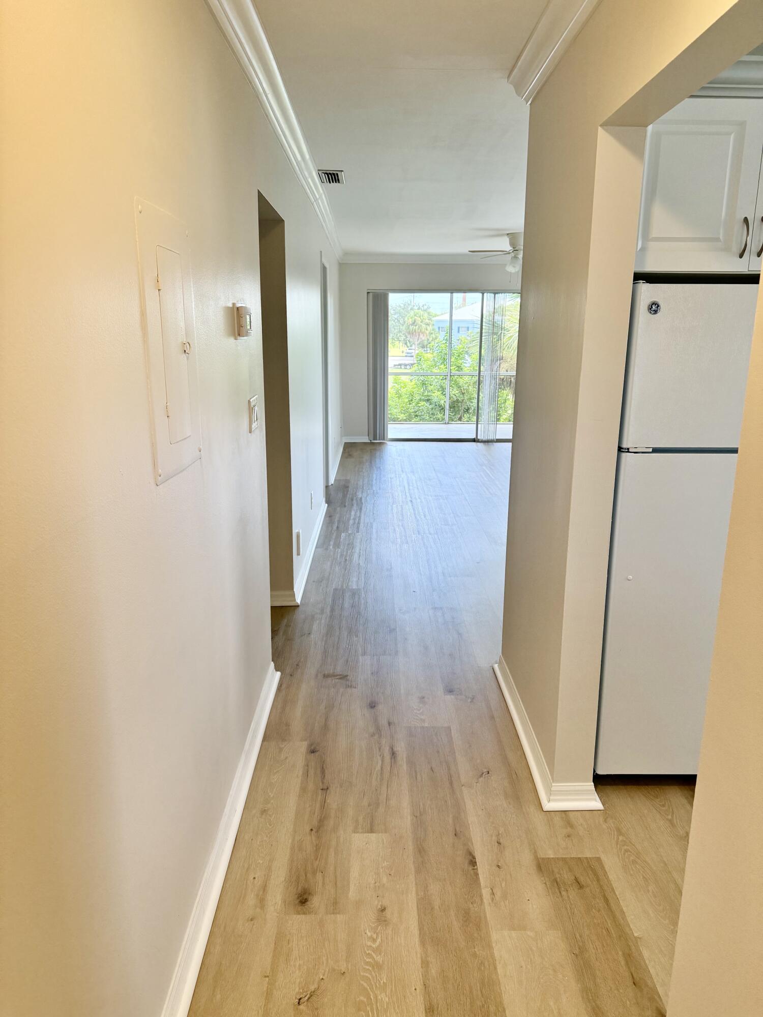 1900 South Kanner Highway, Unit 10207 Stuart, FL 34994 - Photo 16 of 19 a view of a hallway with wooden floor and a refrigerator