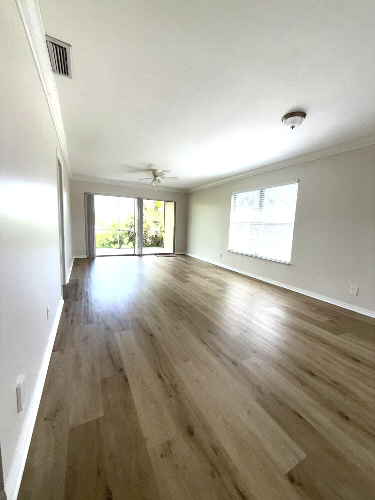 1900 South Kanner Highway, Unit 10207 Stuart, FL 34994 - Photo 2 of 19 an empty room with wooden floor and windows
