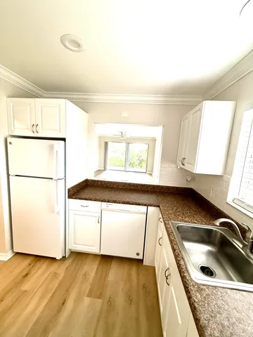 a kitchen with a sink a stove and white cabinets