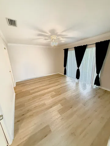 a view of empty room with wooden floor
