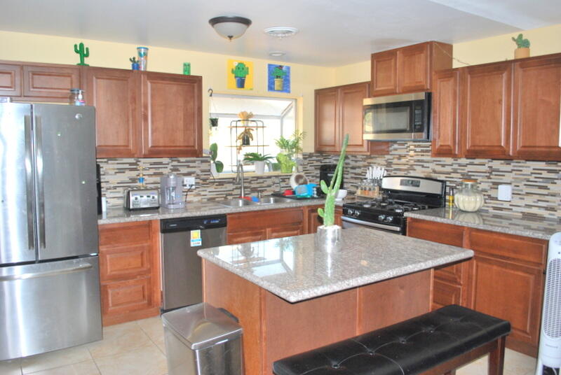 44561 Windsor Drive Indio, CA 92201 - Photo 9 of 22 a kitchen with stainless steel appliances granite countertop a sink refrigerator and microwave