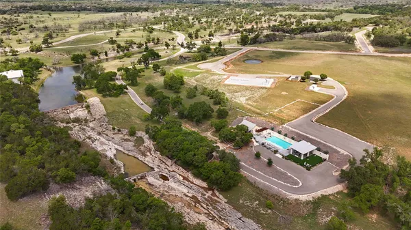 an aerial view of a house with a yard and a lake view