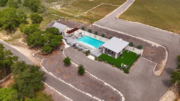 an aerial view of residential houses with outdoor space and trees