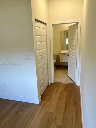 wooden floor in a bedroom next to a bathroom