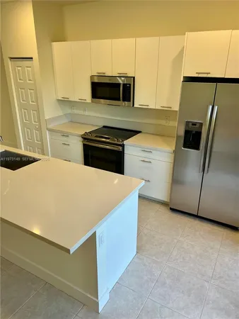 a kitchen with stainless steel appliances a stove microwave and a refrigerator