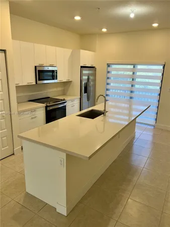a kitchen with stainless steel appliances a microwave and refrigerator