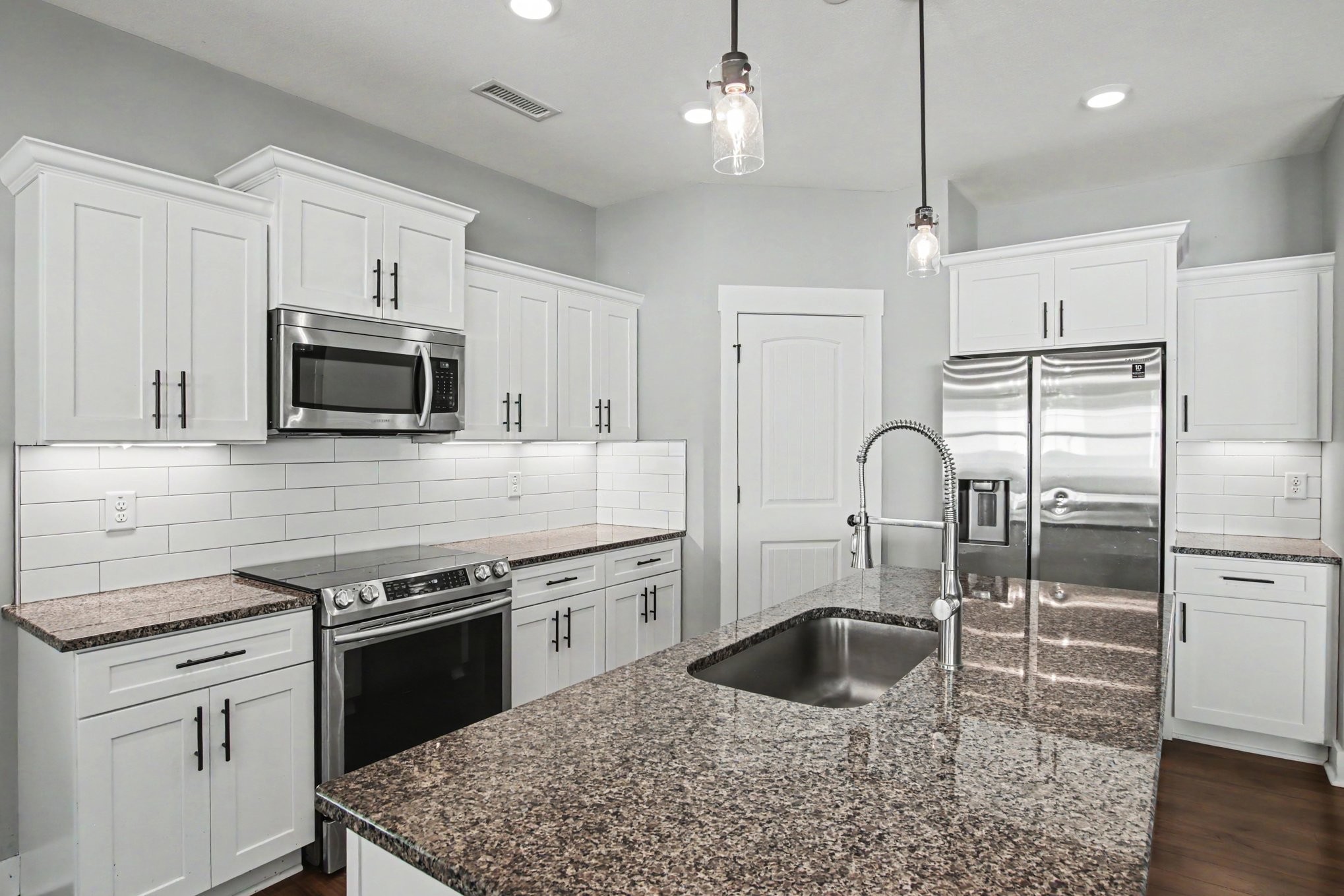 7208 Winding Way Pleasant View, TN 37146 - Photo 11 of 30 a kitchen with granite countertop a stove a sink and a microwave