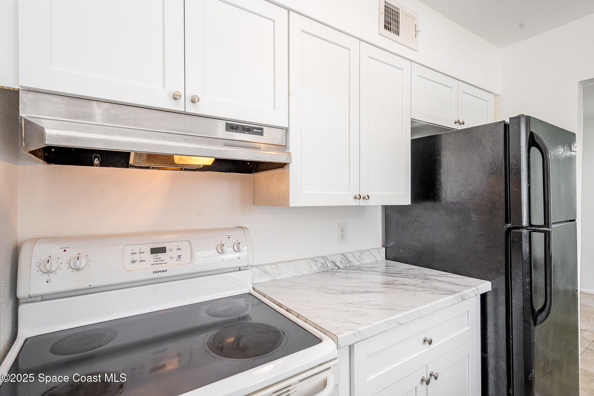 2219 Flower Tree Circle Melbourne, FL 32935 - Photo 16 of 26 a kitchen with a white stove top oven and refrigerator