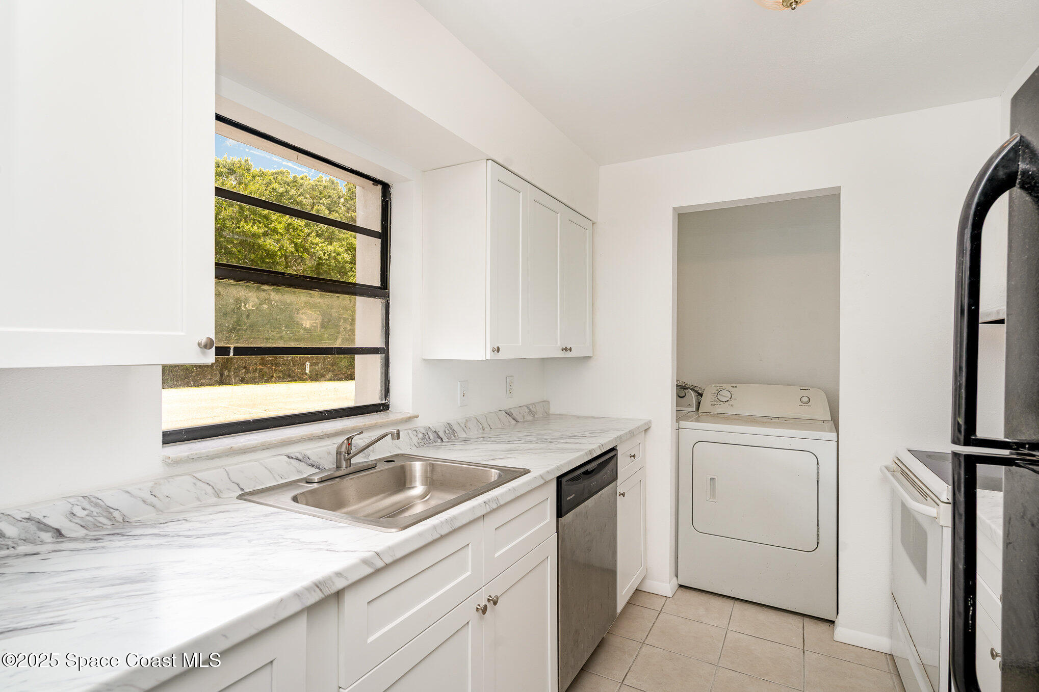 2219 Flower Tree Circle Melbourne, FL 32935 - Photo 3 of 26 a kitchen with a sink stove and refrigerator