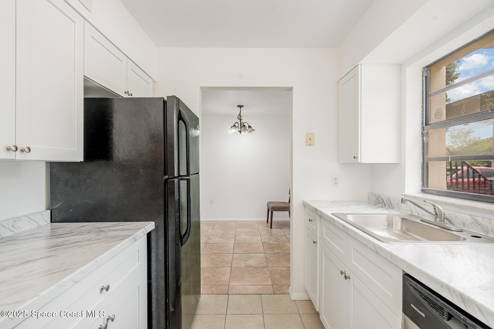 2219 Flower Tree Circle Melbourne, FL 32935 - Photo 4 of 26 a kitchen with a sink a refrigerator and a stove