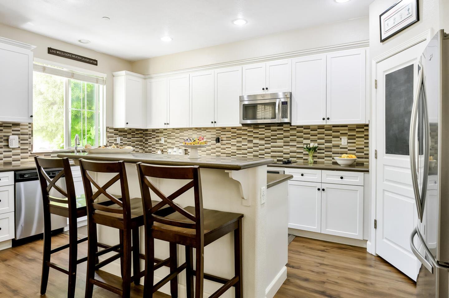 140 Larkspur Loop Morgan Hill, CA 95037 - Photo 11 of 28 a kitchen with stainless steel appliances granite countertop white cabinets and wooden floor