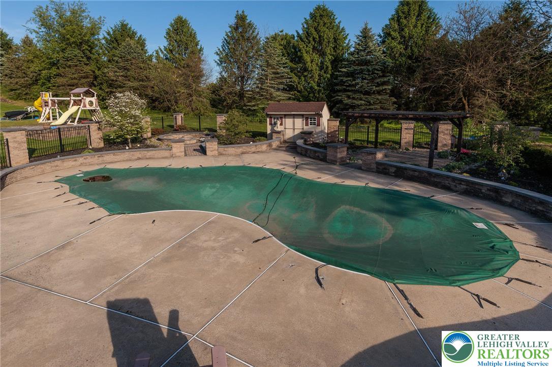 2170 Clearview Road Coplay, PA 18037 - Photo 63 of 75 An inviting backyard oasis offers a covered pool, an adjacent shed, and a shaded pergola for outdoor enjoyment.