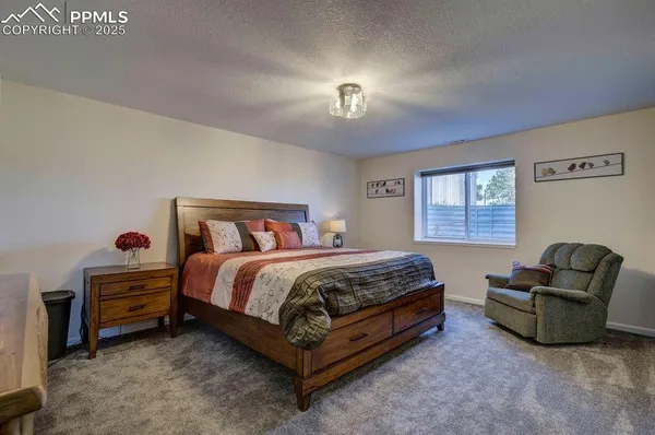 a spacious bedroom with a bed and a chandelier