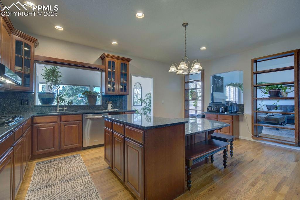 14650 Eastonville Road Elbert, CO 80106 - Photo 9 of 44 a kitchen with stainless steel appliances granite countertop a refrigerator a sink dishwasher a dining table and chairs with wooden floor