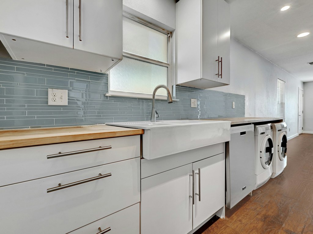 a kitchen with white cabinets and sink