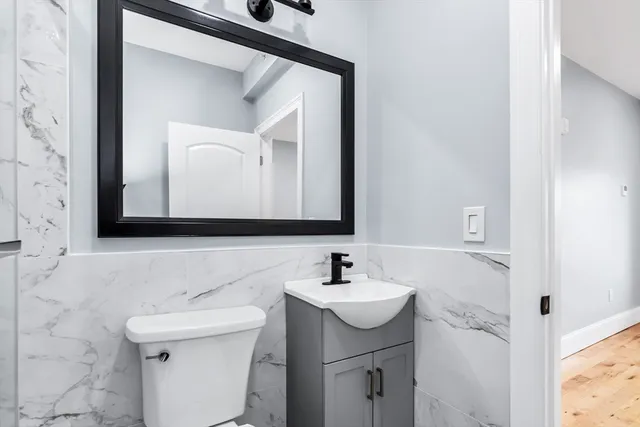 a bathroom with a toilet sink and mirror