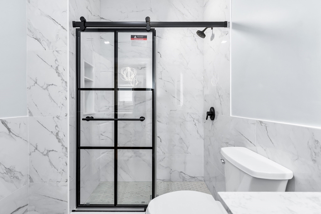 50 Maverick Street, Unit 3 Chelsea, MA 02150 - Photo 9 of 24 a white toilet sitting next to a shower