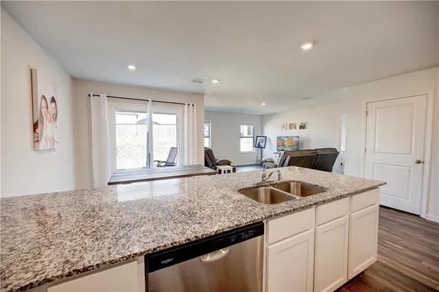a kitchen with granite countertop a sink and a wooden floor