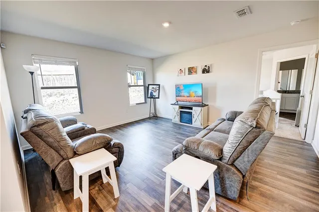 a living room with furniture and a wooden floor