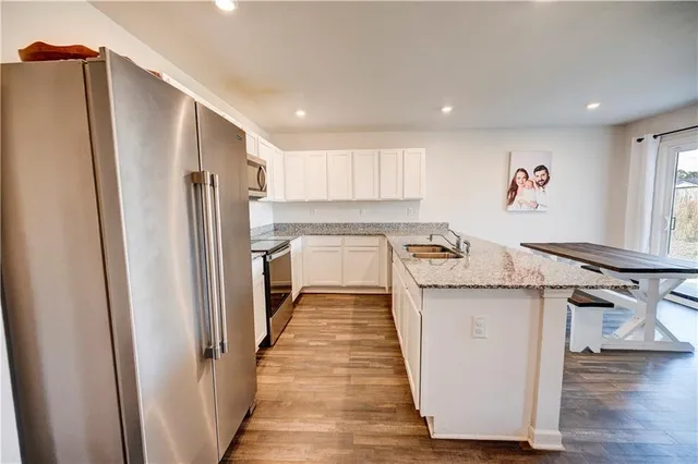 a kitchen with kitchen island wooden floor and refrigerator