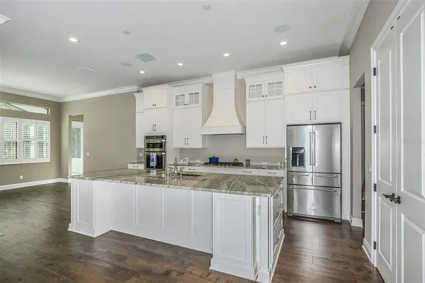 a kitchen with stainless steel appliances granite countertop a refrigerator and a stove top oven