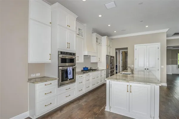 a kitchen with white cabinets and stainless steel appliances