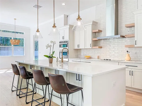 a kitchen with stainless steel appliances kitchen island granite countertop a sink a refrigerator and a wooden cabinets