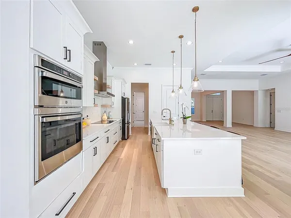 a large kitchen with stainless steel appliances a stove a sink and a refrigerator