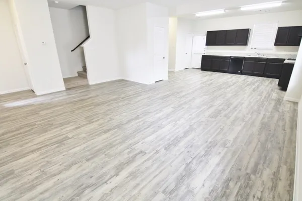 a view of a kitchen with wooden floor and electronic appliances