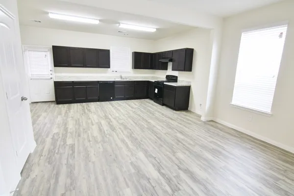 a large white kitchen with a sink and microwave