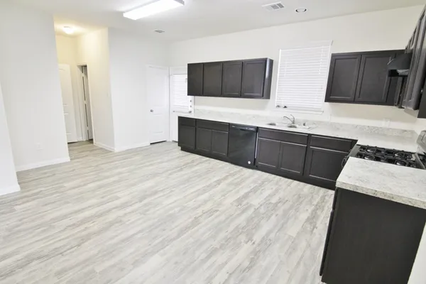 a kitchen with stainless steel appliances kitchen island granite countertop a sink stove and refrigerator