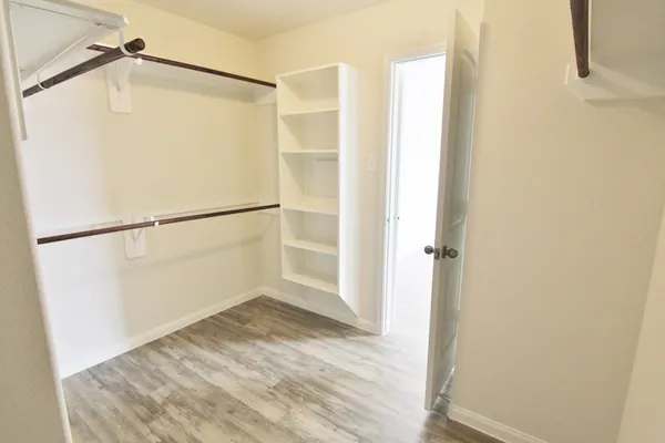 a view of walk in closet with empty racks