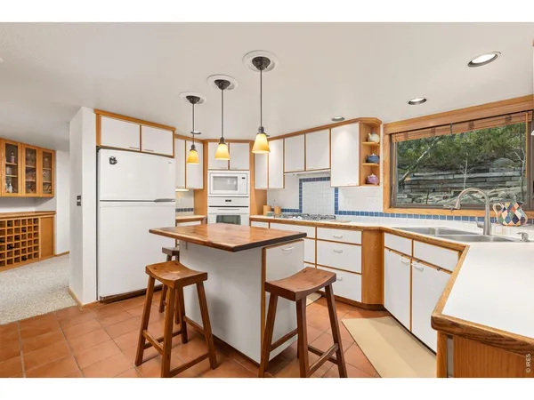 a kitchen with stainless steel appliances granite countertop a sink and a refrigerator