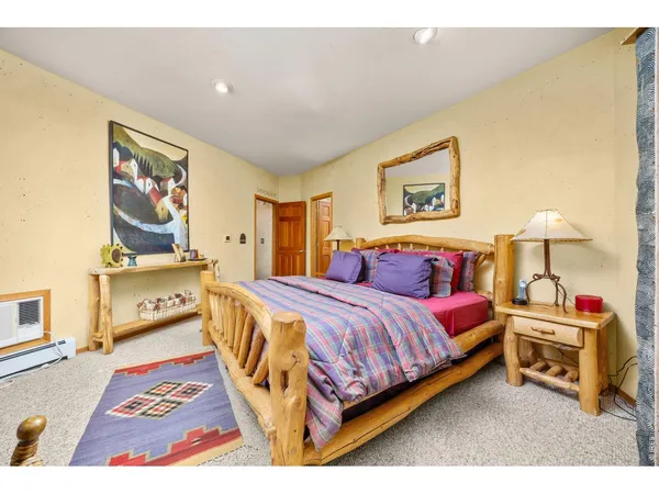 a spacious bedroom with a bed a dresser and next to a window
