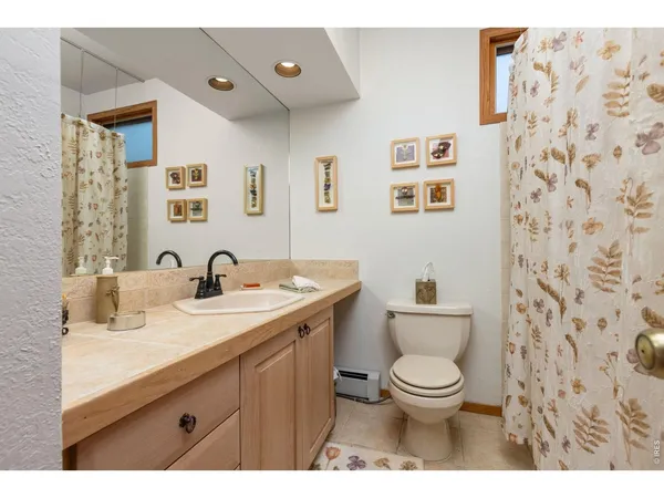 a bathroom with a granite countertop toilet a sink and a mirror