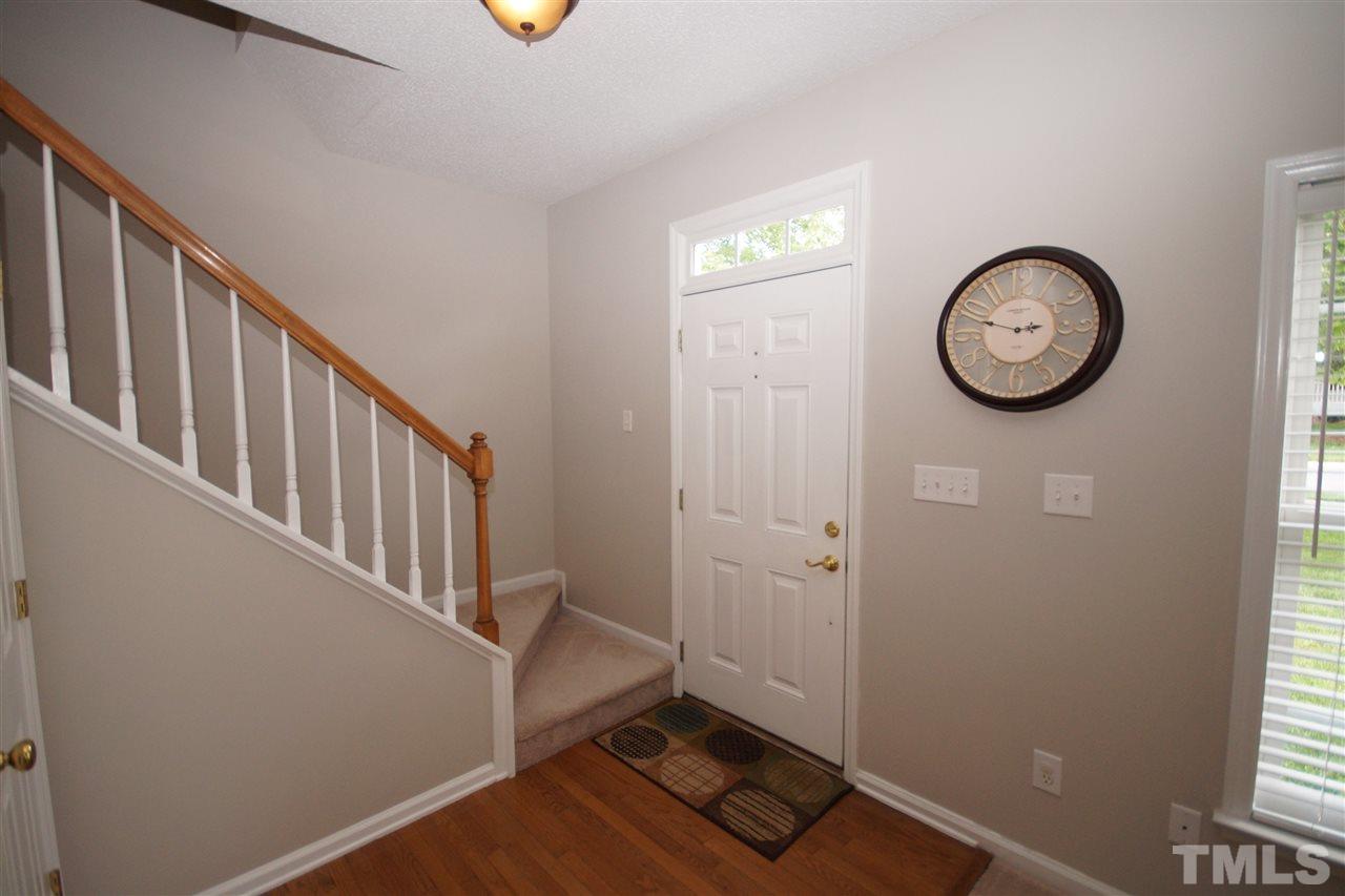 9241 Shallcross Way Raleigh, NC 27617 - Photo 2 of 22 a view of a hallway with wooden floor and door