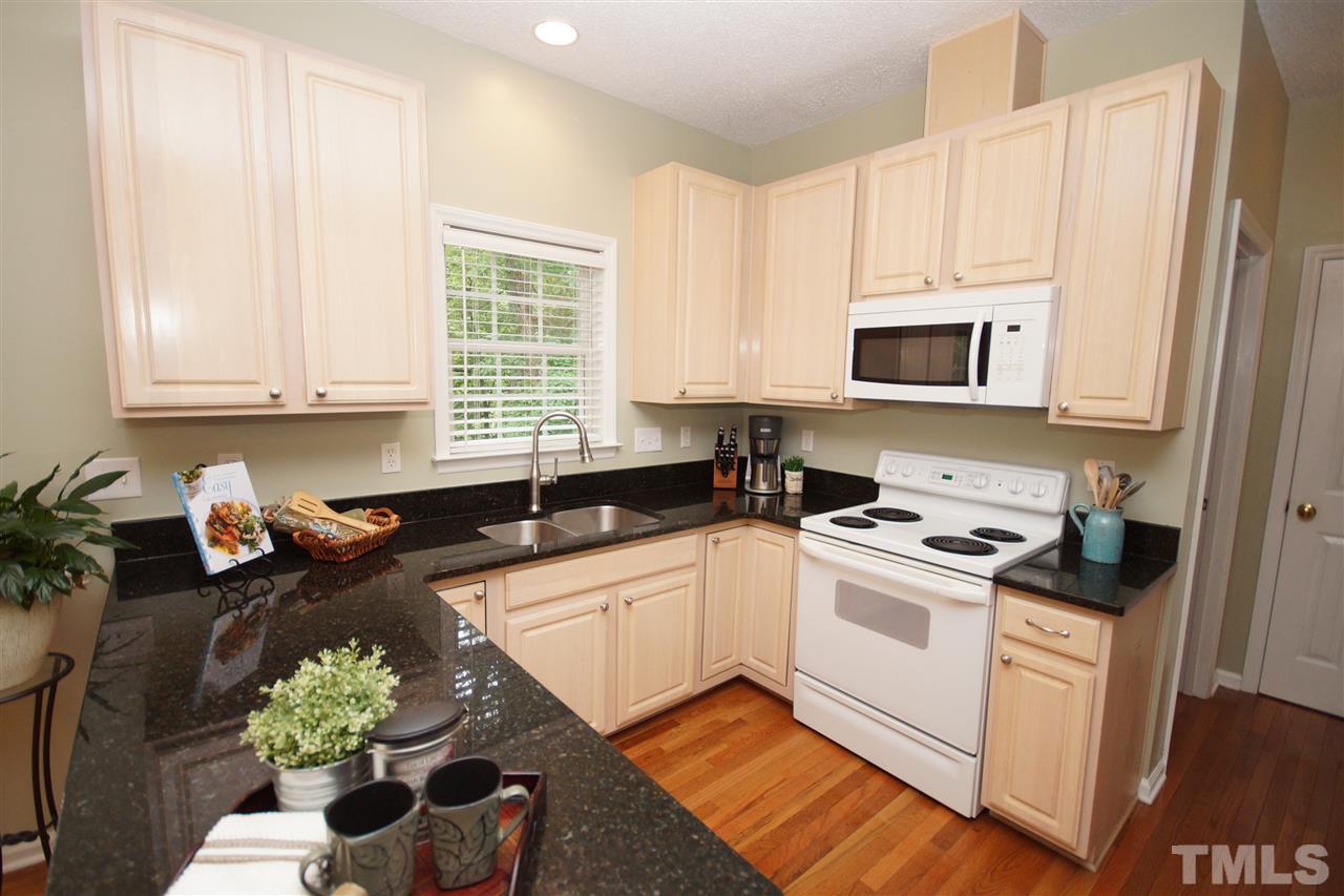 9241 Shallcross Way Raleigh, NC 27617 - Photo 11 of 22 a kitchen with granite countertop a sink a stove a microwave and cabinets